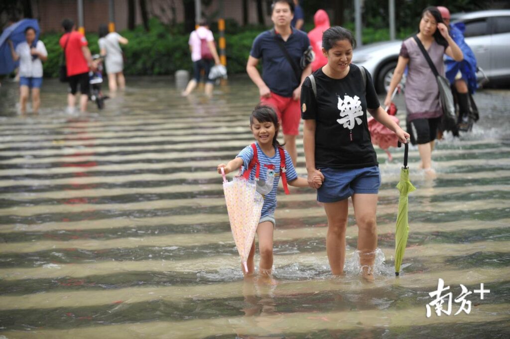 广东暴雨：街头积水市民骑车如渡河