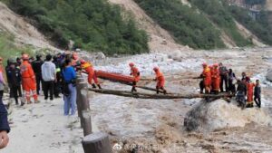 消防员背抬地震伤者踩木桥渡河