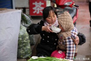 单亲妈妈冷风中带女儿路边卖干菜