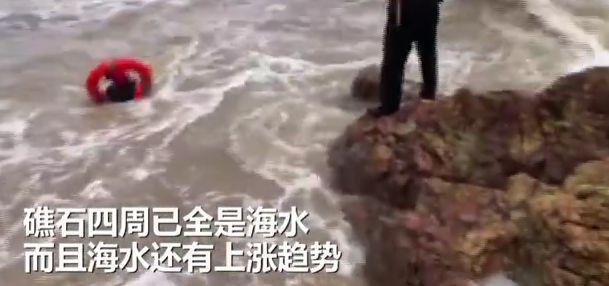 男子站临海近乎垂直石壁上钓鱼